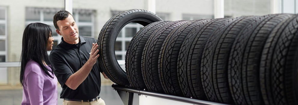 Subaru service representative showing customer a tire. | Mid-Hudson Subaru in Wappingers Falls NY